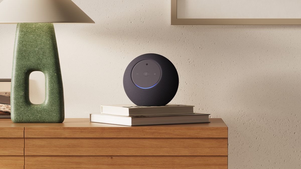 Amazon Echo Studio con cámara en color negro sobre unos libros encima de una cómoda de madera